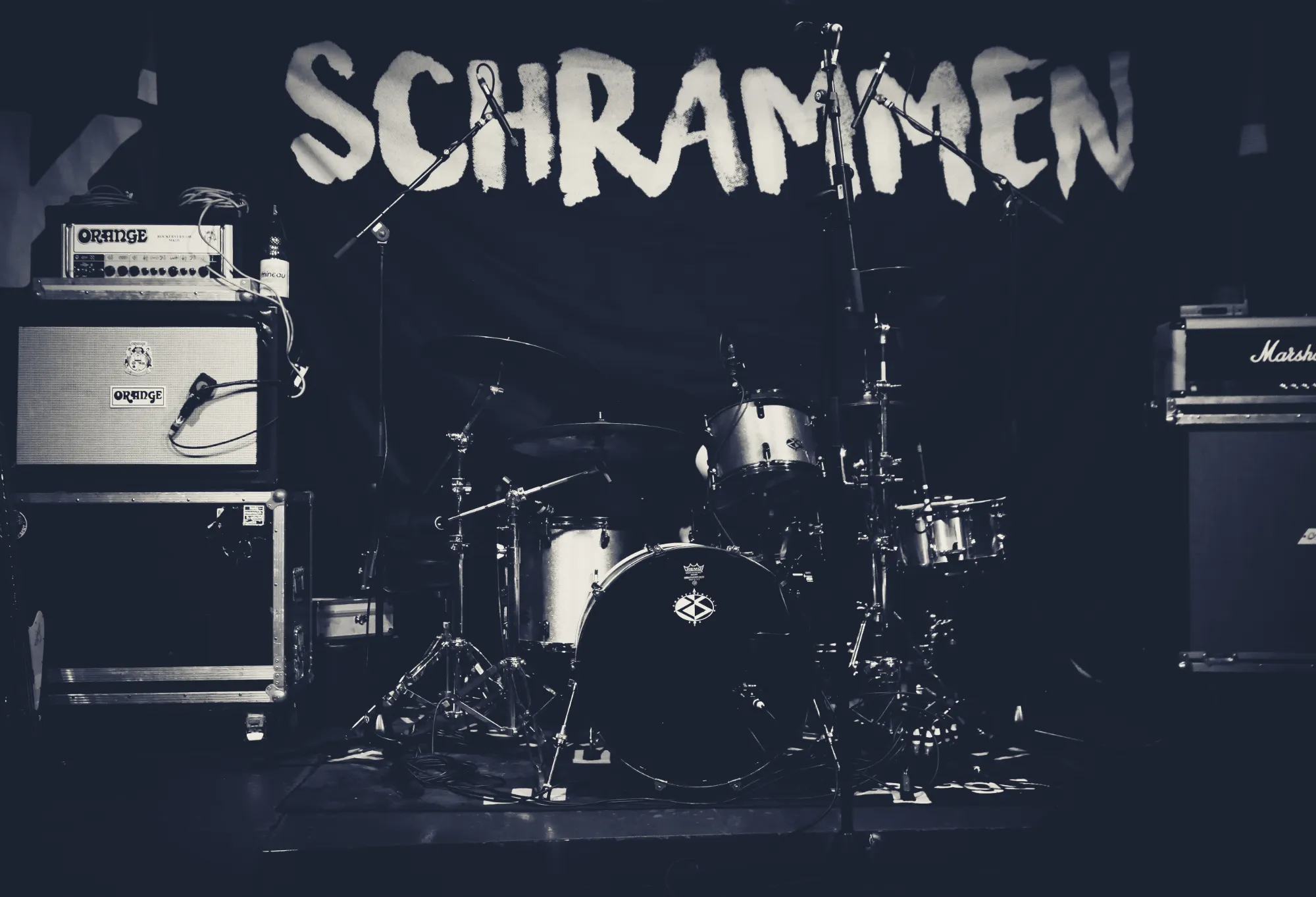 Schlagzeug und Verstärker vor dem SCHRAMMEN-Banner